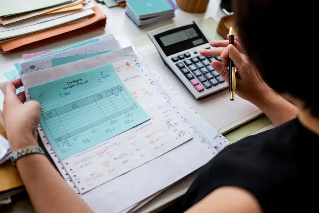asian women working accounting and calculating for taxes and invoices